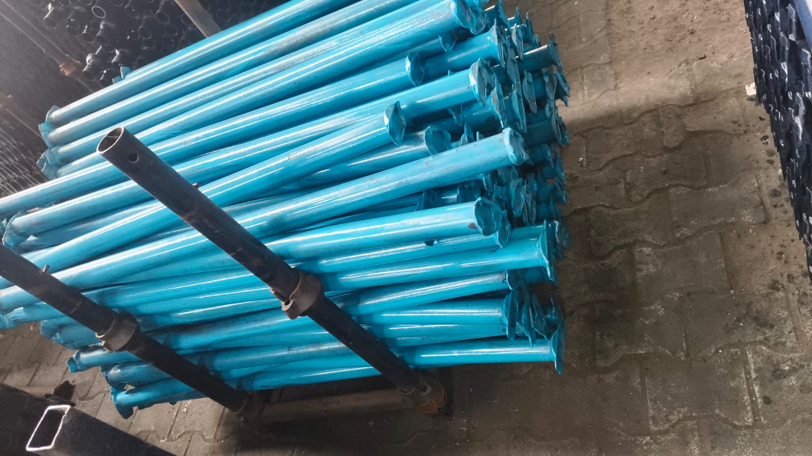 Batch of blue-painted steel scaffolding props arranged together at the factory for identification and dispatch